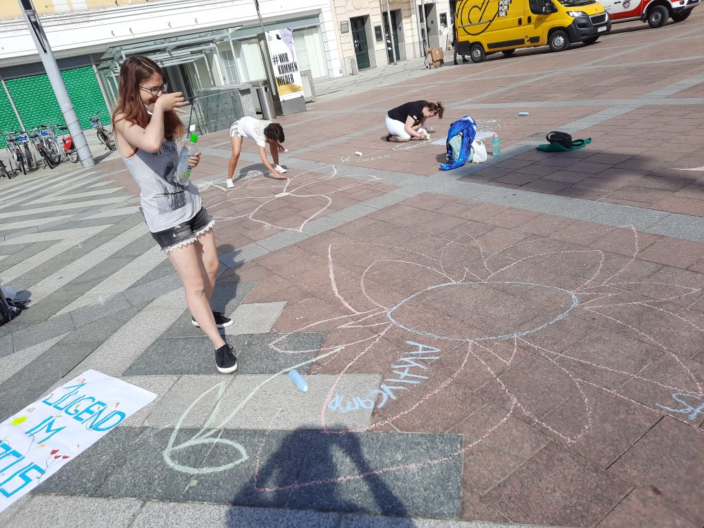 Straßenaktion Jugend im Fokus: Teilnehmerin mit gemalter Blume